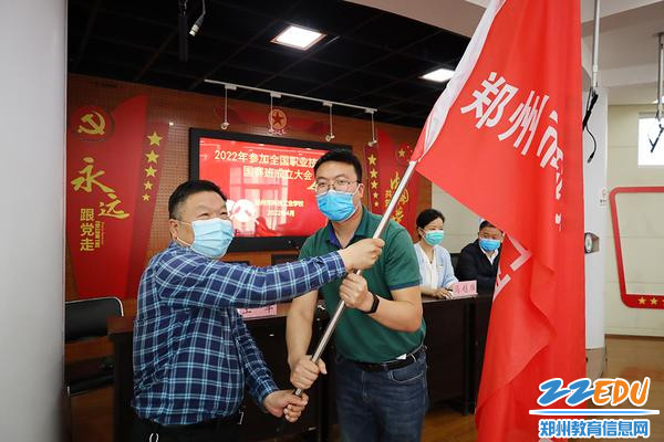 校长支德银向国赛班班主任李艳魁授旗