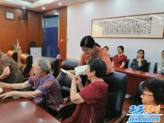 段亚萍为老党员发放党史学习书籍1