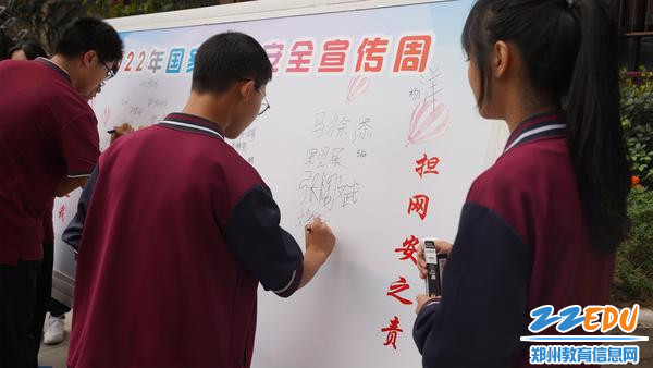 学生在签名展板上签名