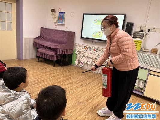 4.教师向幼儿讲解示范灭火器的正确使用方法