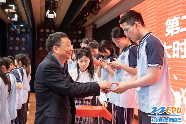 6郑州市第十九高级中学党委书记、校长梁寅峰为新团员颁发团章、团员证和团徽_副本