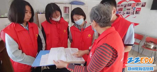 郑州火车站老年雷锋团团长姚淑英给“绿苗”志愿者讲解如何帮助旅客