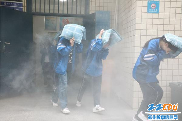 同学们护头弯腰捂口鼻，快速有序撤离宿舍楼