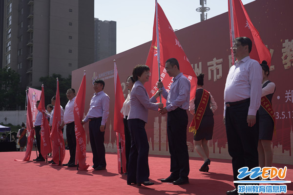 1郑州市教育局党组书记、局长王丽娟为郑州市商贸管理学校授旗