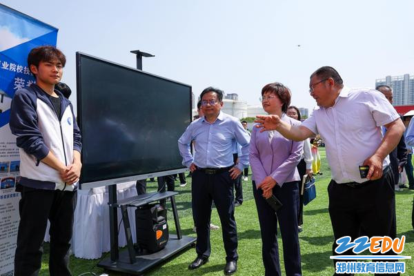 3校党委书记邵元辉向郑州市教育局党组书记、局长王丽娟汇报学校展位展示情况