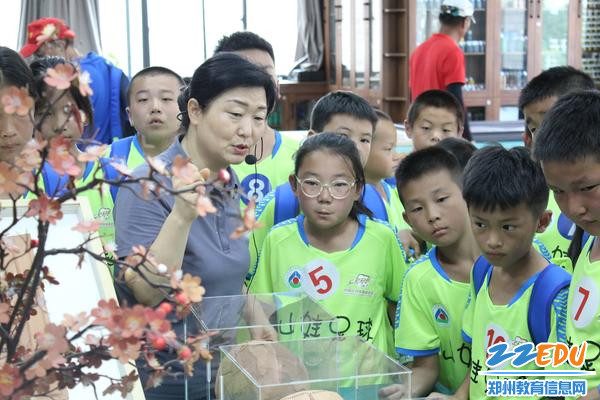 图5 朱冬梅主任向足球宝贝们介绍足球系列皮艺作品