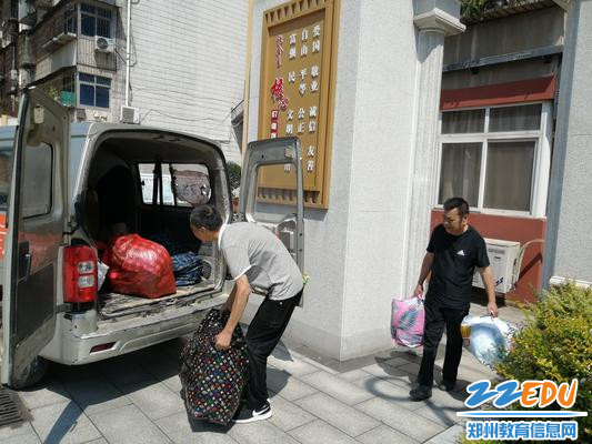 学校职工将收集的救灾物资搬运上车