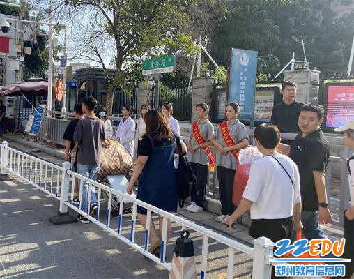 2教师及学生礼仪队在校门口迎接新生