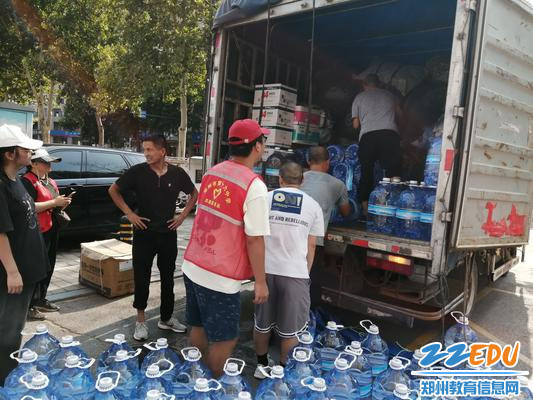 大家把纯净水、消毒液等物资装车