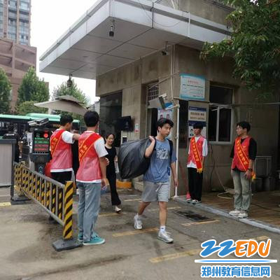 2.志愿者们在校门口迎接新生