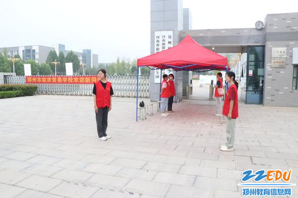 2.志愿者在大门口迎接新生到来