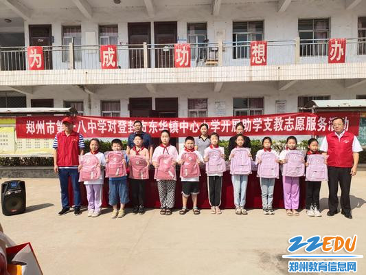 魏勇代表郑州18中为登封市东华镇中心小学捐赠书包