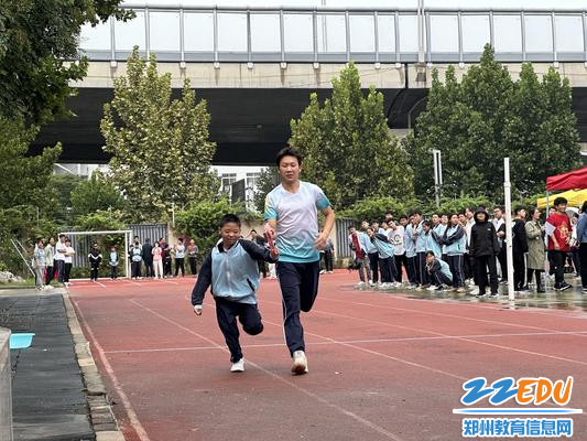 聋生志愿者辅助盲小学学生参与100米比赛