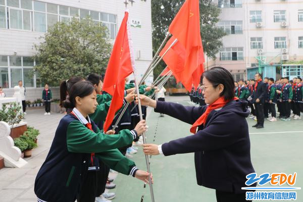 郑州57中工会主席吴琪、副校级干部赵虹珂为各中队授中队旗