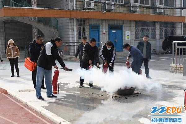 教职员工在消防员指导下进行灭火演练