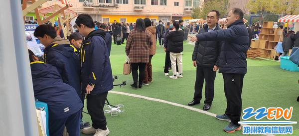 2。郑州34中党委书记常晋波（左）倾听讲解